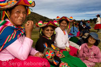 Varias mujeres del pueblo de Llachón vestidas con un trajes típicos regionales asisten como público a un partido de fútbol.